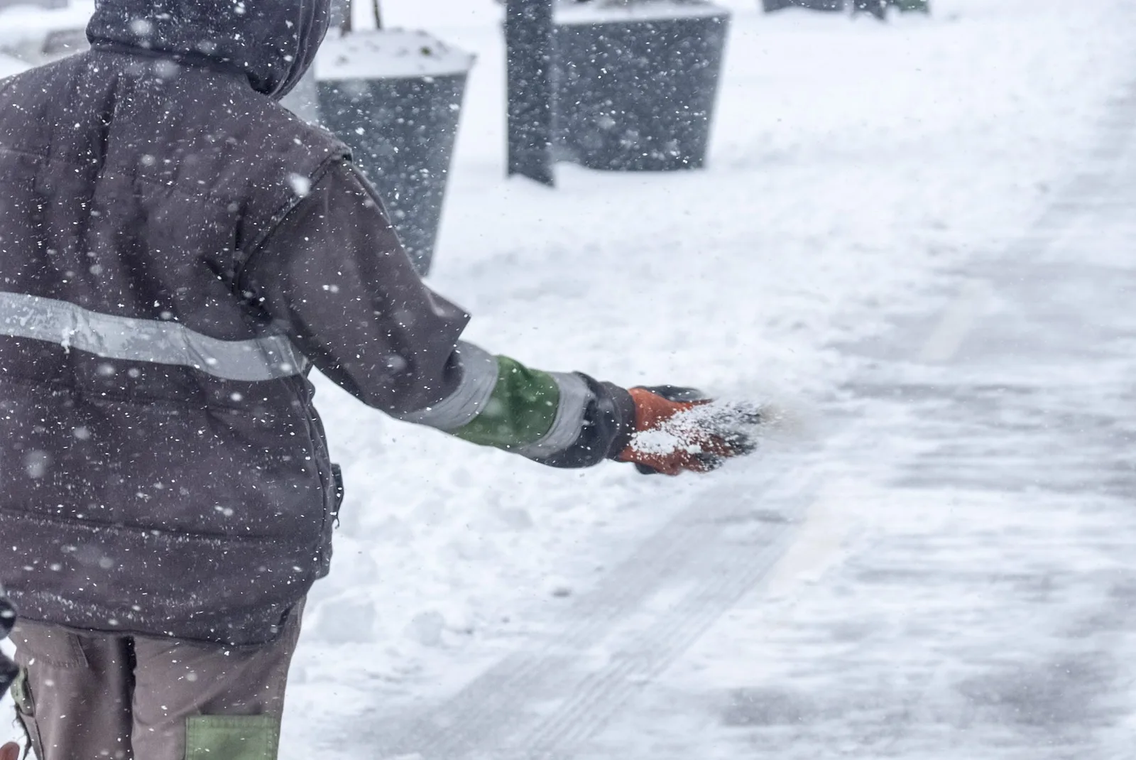Commercial ice removal De Pere, WI deicing a storefront walkway